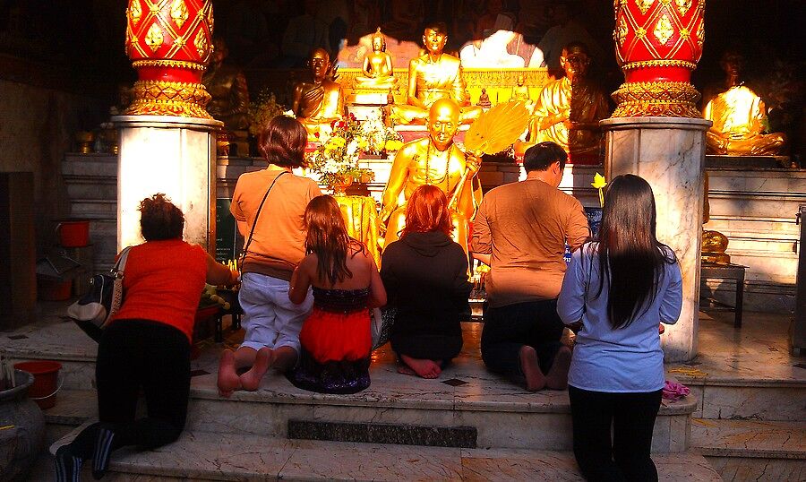 Тайцы молятся каким-то позолоченным дядькам...